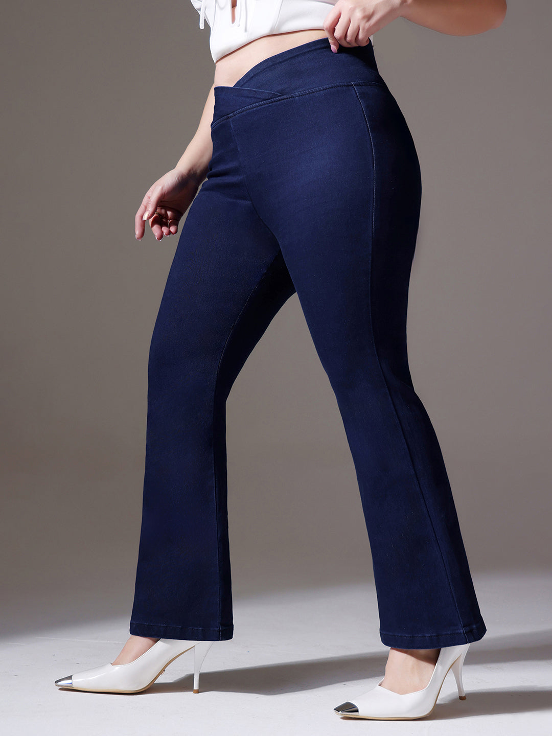 Mid-sized woman wearing a pair of Bootcut High-Rise Navy Blue Denim Jeans which provides light tummy smoothening with the patented CHASEshapeTM Panel
