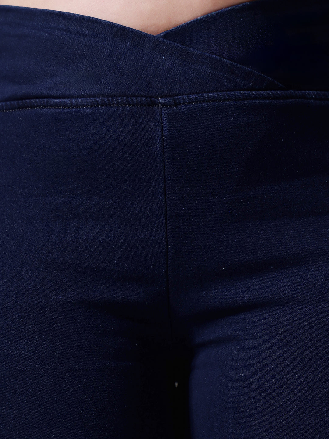 Mid-sized woman wearing a pair of Bootcut High-Rise Navy Blue Denim Jeans which provides light tummy smoothening with the patented CHASEshapeTM Panel