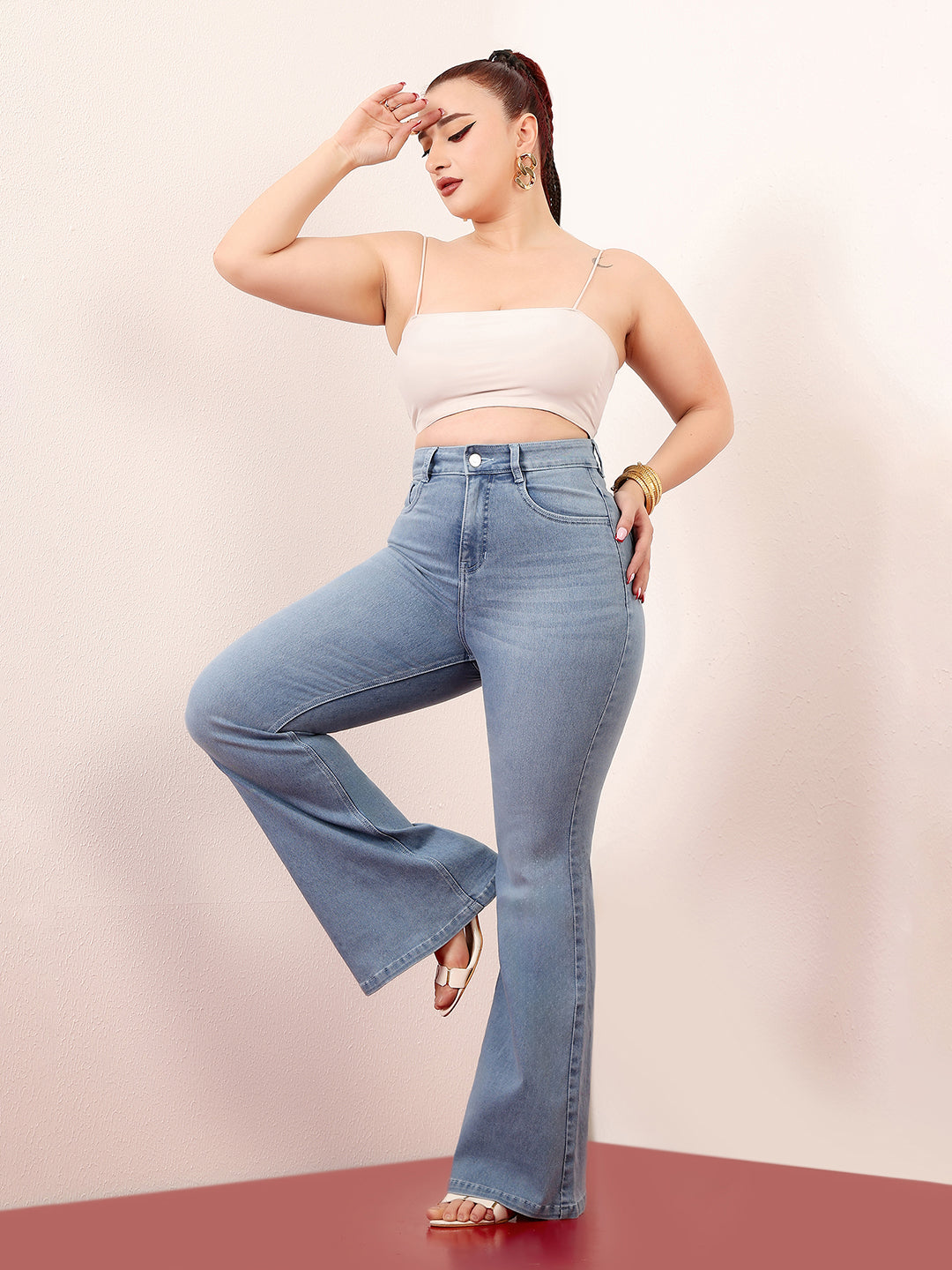Mid-sized woman wearing a pair of Bootcut High-Rise Light Blue Denim Jeans which provides light tummy smoothening with the patented CHASEshapeTM Panel