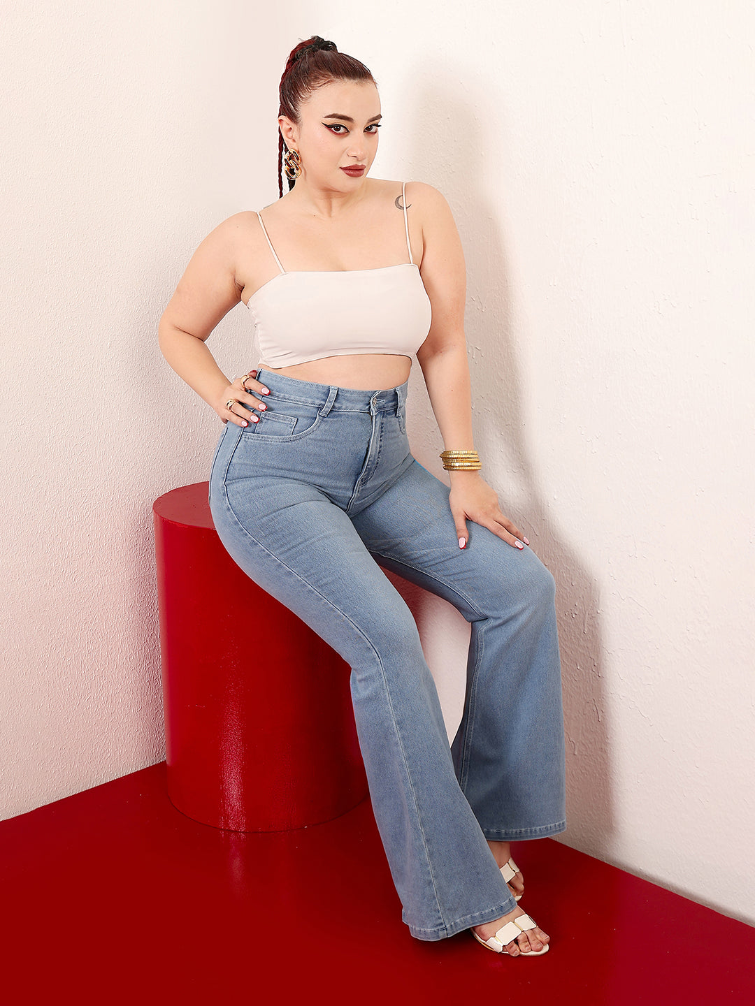Mid-sized woman wearing a pair of Bootcut High-Rise Light Blue Denim Jeans which provides light tummy smoothening with the patented CHASEshapeTM Panel
