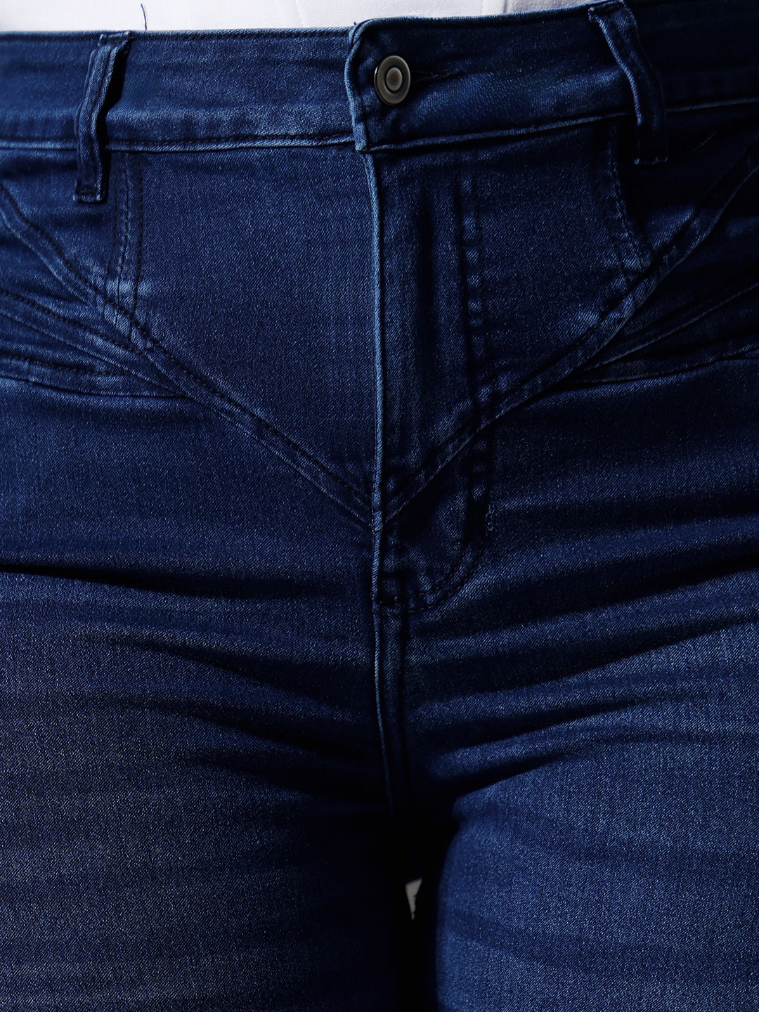 Mid-sized woman wearing a pair of Bootcut High-Rise Navy Blue Denim Jeans which provides light tummy smoothening with the patented CHASEshapeTM Panel